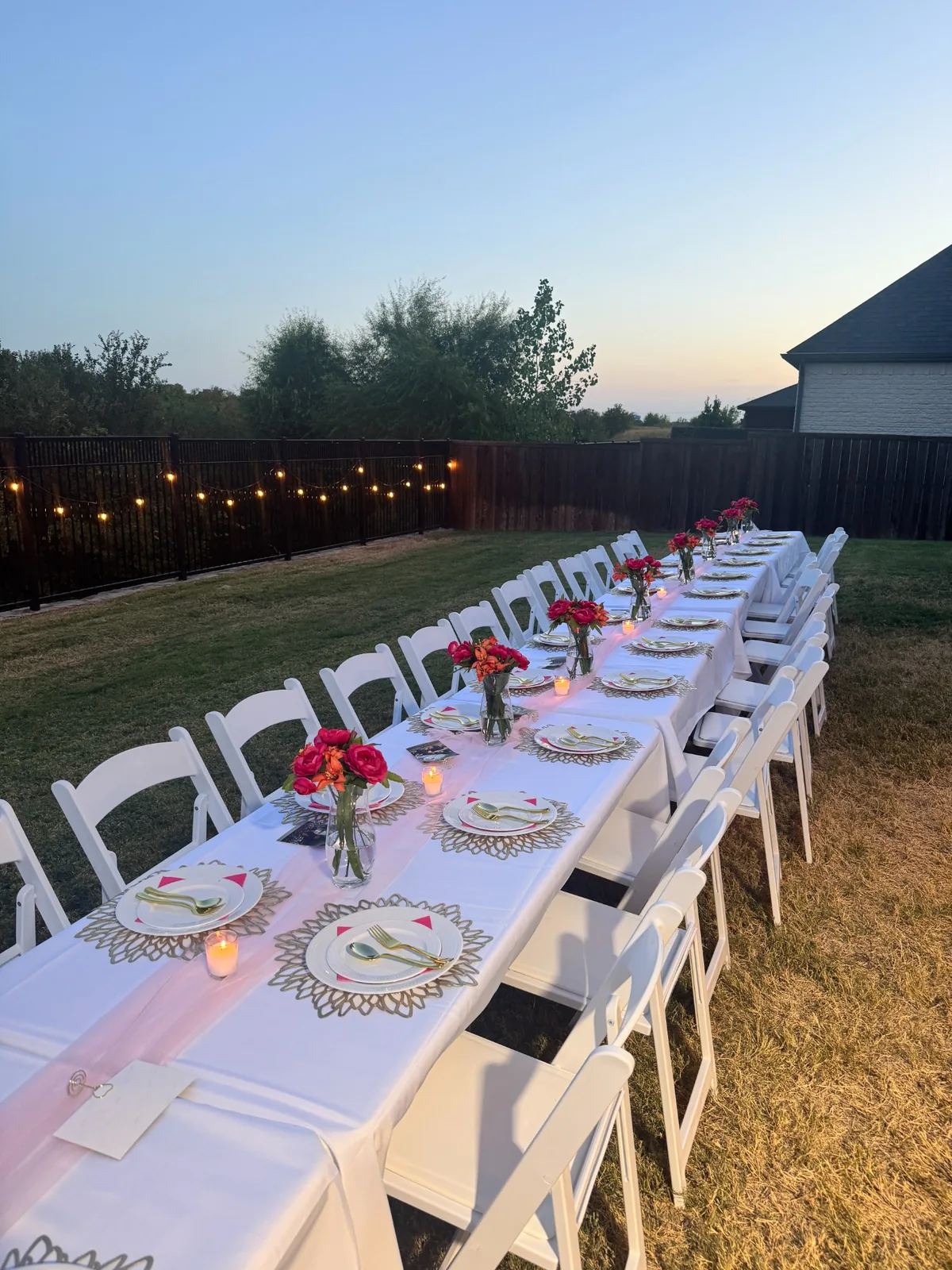Sweet Sixteen outdoor tablescape with white chairs, floral centerpieces and place settings